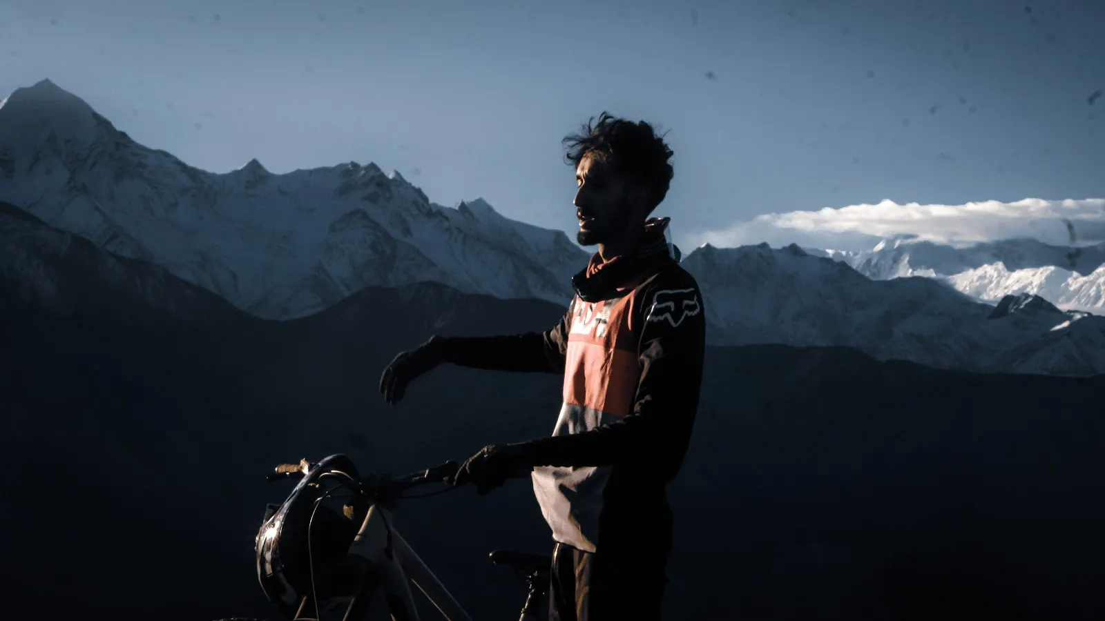 Rider beside a mountain bike with the Himalayan range behind