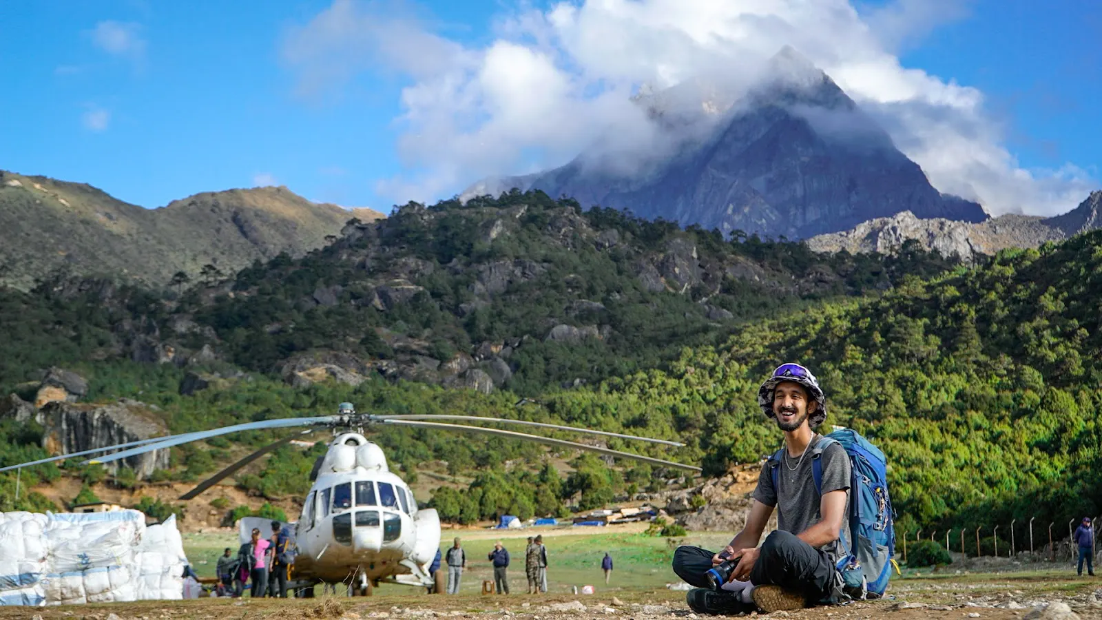 Filmmaker in front of a helicopter and mountains
