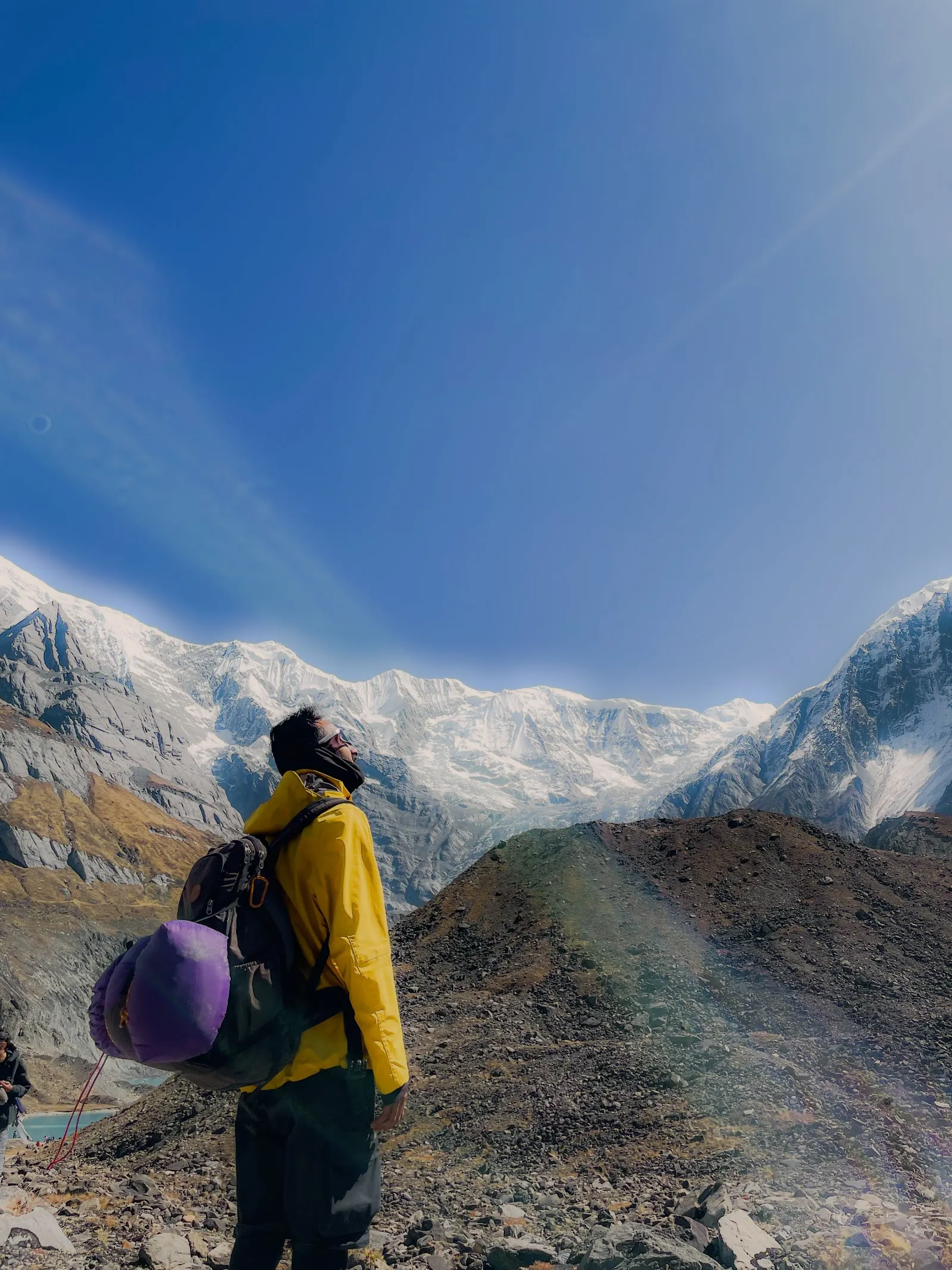 Walker in a yellow jacket beneath snow-covered mountains