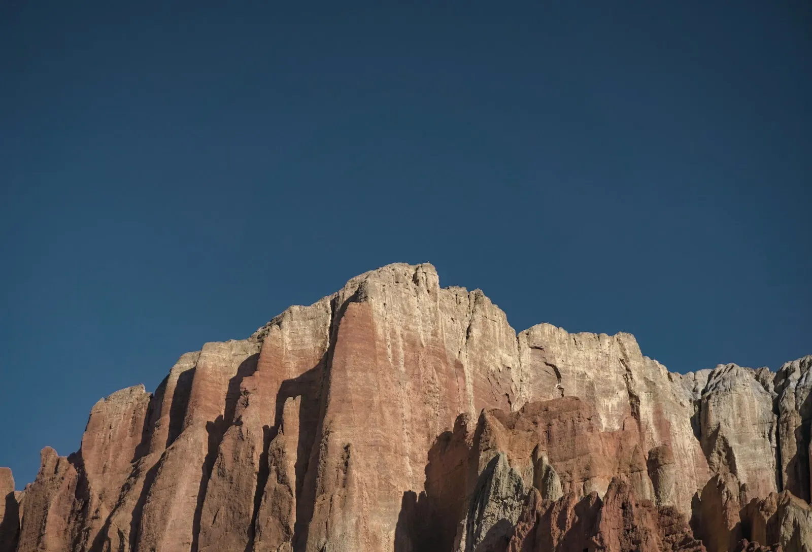 Warm cliffs beneath a dark blue sky