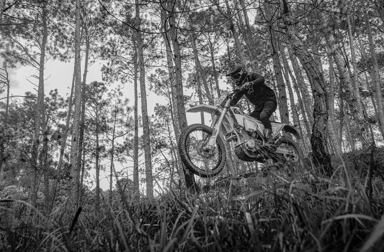 Rider lifting a motorbike through a forest